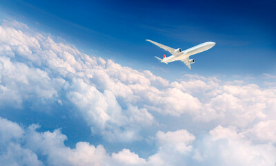 Commercial airplane flying above clouds in blue sky