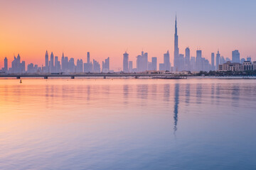 Fototapeta na wymiar sea bay with reflections of skyscrapers in water in Dubai in the morning with copy space