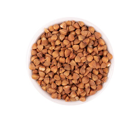 Roasted buckwheat grains in bowl, isolated on white background. Dry brown buckwheat groats. Top view.