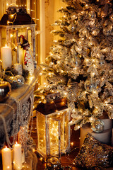 warm and cozy evening in Christmas room interior design,Xmas tree decorated by lights presents gifts,toys, deer,candles, lanterns, garland lighting indoors fireplace.holiday living room.magic New year