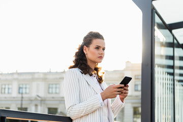 Fototapeta premium Business woman texting messages while walking. Woman with phone in subway train station. Transport app concept. Travel app.