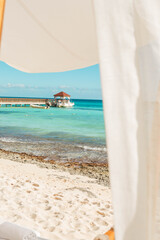 Fototapeta na wymiar Paraiso Vacacional, mar azul, arena blanca y un bello puente con una romantica villa al fondo 