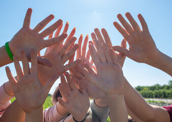 Group of students raised hands in air