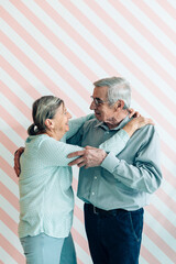 Senior couple enjoying and dancing together indoors at home - Focus on senior man face
