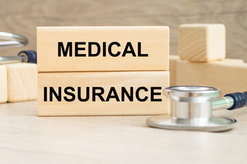 the word MEDICAL INCURANCE is written on a wooden cubes structure . Can be used for Medical concept.