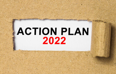 The text ACTION PLAN behind torn brown paper. Business Concept image