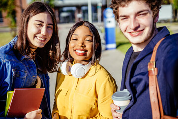 Photo portrait of mixed raced group of three friends millennial students meet together outdoor.