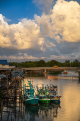 Fototapeta premium Thai fishing boats moored at the pier in the evening at sunset in fishing village, Ban Pak Nam Khaem Nu, Chanthaburi, Thailand.