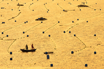 China Fujian Province Xiapu Xiaqingshan. The water of the river speckled by fish pots and is lit by the setting sun. sun