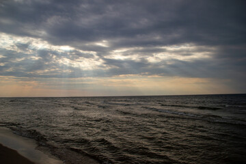 Sunshine through heavy clouds in the sea on a sunset