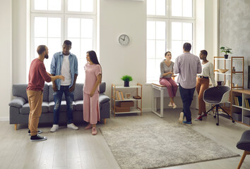Caucasian and African American women and men communicate with each other at home. Friends split...