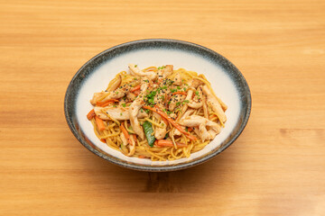 Yakisoba noodles sauteed with carrots, zucchini and chicken strips with poppy seeds and sesame with chives