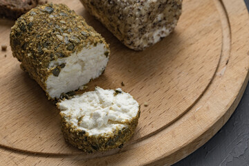 demonstration of soft white cheese with spices on a dark table