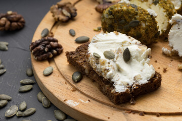 soft cheese on a cutting board and pumpkin seeds