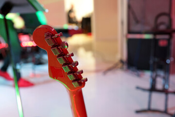 Gryf gitary na kolorowym tle estrady muzycznej,