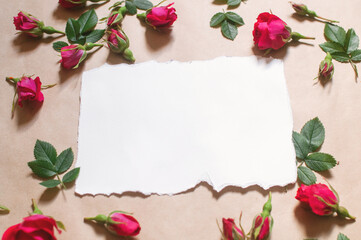 blank white paper, red buds flowers and rose petals