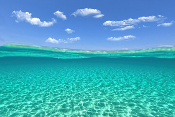 Split underwater photo of exotic island paradise bay with crystal clear emerald sandy beach