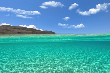 Fototapeta na wymiar Split underwater photo of exotic island paradise bay with crystal clear emerald sandy beach