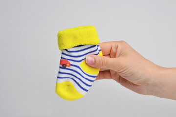 Baby socks for newborn in hand on white background isolated.  Happy pregnancy, waiting for the baby. Copy space.