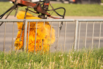 A fragment of a street washer washing dirt from a road fence with a brush. Selective focus.