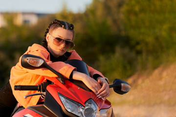 A motorcycle ride. A girl on a motorcycle in nature. Copy space.