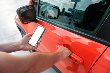 A man using a smartphone near his car. Mobile phone applications for car lock owners concept