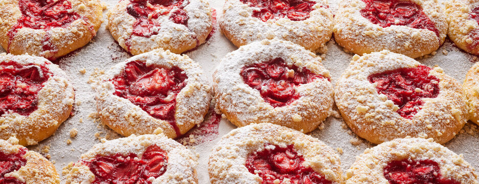 Sweet homemade yeast rolls with the addition of strawberries and butter crumble sprinkled with powdered sugar. Traditional sweet pastries called kolaches