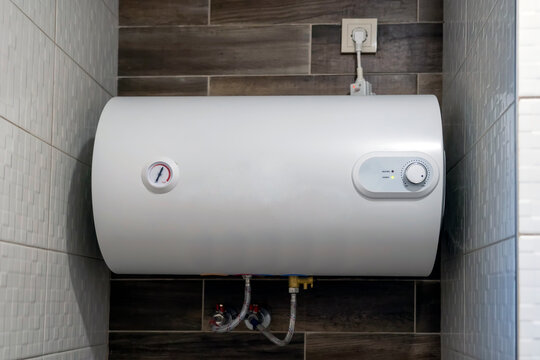 Modern White Electric Water Heater on Beige Ceramic Tile Wall