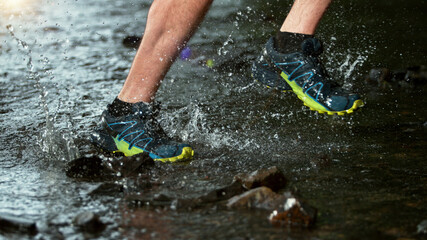 Close-up of man feet running in water, freeze motion.