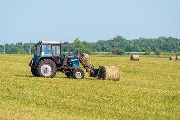 Harvesting hay on a tractor.