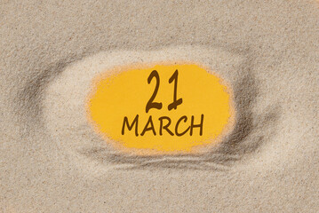 March 21. 21th day of the month, calendar date. Hole in sand. Yellow background is visible through hole. Spring month, day of the year concept