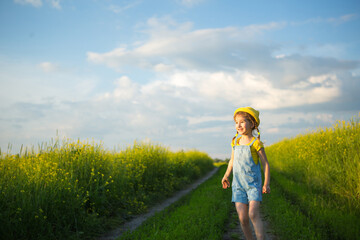 Cheerful girl in a yellow hat in a summer field laughs and smiles. Joy, sunny weather, holidays. A remedy for mosquitoes and insects. Lifestyle, kind face, close-up portrait, enjoying freedom