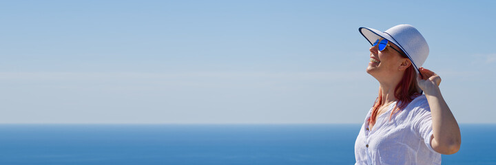 Tourist woman in a white straw hat on beautiful blue Adriatic Sea background. Croatia during summer holiday. Luxury life at holiday at turquoise sea, ocean. Travel concept