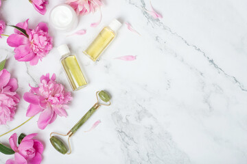 face care, facial massager, peonies on a white table.