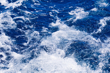 Abstract blue sea water with white wave for background. Adreatic sea, blue mediterranean sea. sea splash sailing boat trail on the water