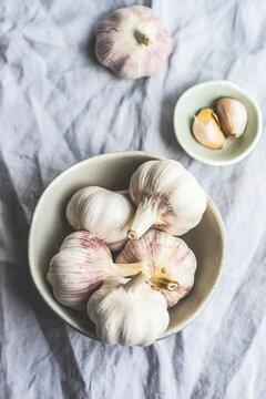 Overhead view of fresh cloves of garlic and garlic bulbs on a table