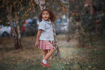 Adorable little girl outdoors at beautiful autumn day