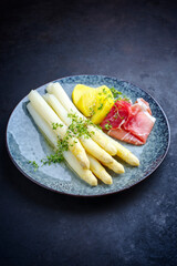 Traditional steamed white asparagus with cured ham and boiled potatoes garnished with butter sauce...