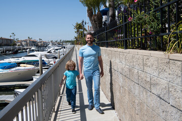 Taking walk together. Father and son promenade holding hands. Man and boy child enjoy leisurely walk