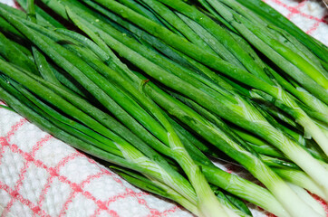 sliced green onions on a wooden board with a tea towel