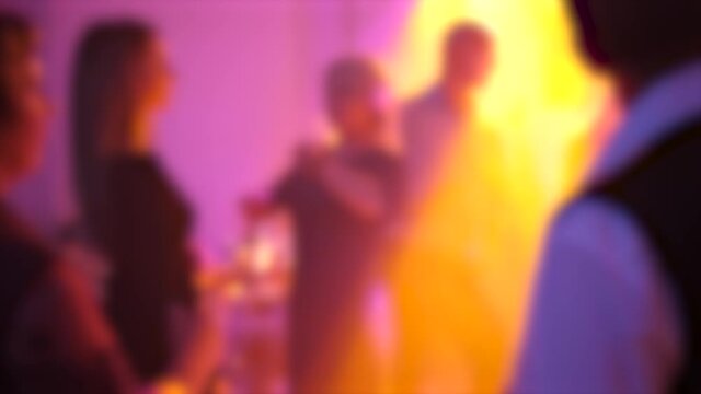 dancing people with color lighting blurred background
