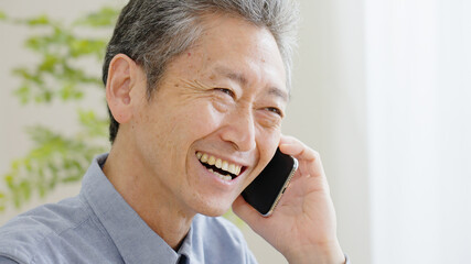スマホで電話するシニア男性