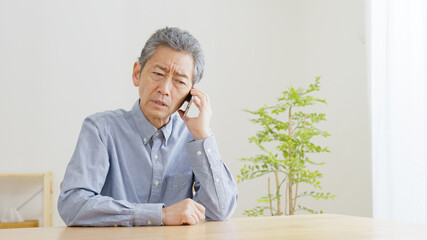 スマホで電話するシニア男性