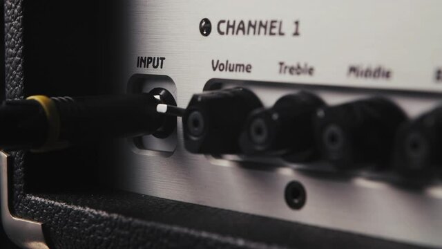 plugging cable into the guitar amp