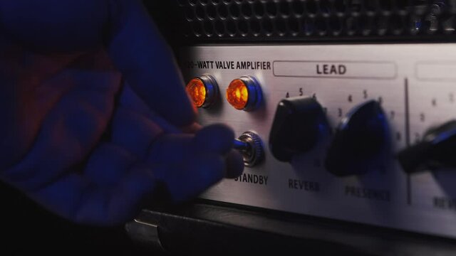 turning on a guitar amplifier button