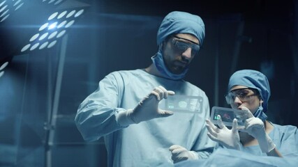 Professional Surgeon and Assistant Analyze Patient Diagnosis Data on Transparent Phones During Surgery. Modern Hospital Operating Room. Shot on RED Epic-W Helium Camera. - Powered by Adobe