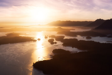 Fototapeta premium Aerial Canadian Landscape at the West Pacific Ocean Coast. Bright colorful vibrant sunset Art Render. Taken from Airplane in Tofino, Vancouver Island, British Columbia, Canada.