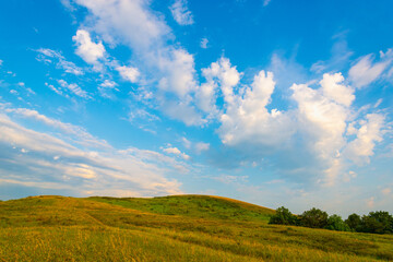 Small mountains blue sky with clouds.