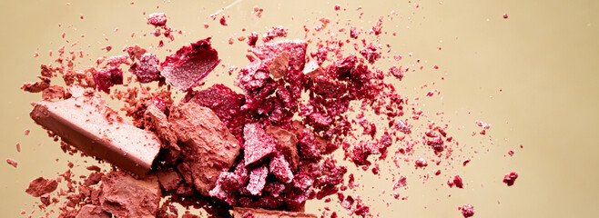 Crushed cosmetics, mineral organic eyeshadow, blush and cosmetic powder isolated on golden...