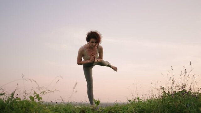 Young woman practicing yoga in the nature. Young woman position enjoying meditating outdoors